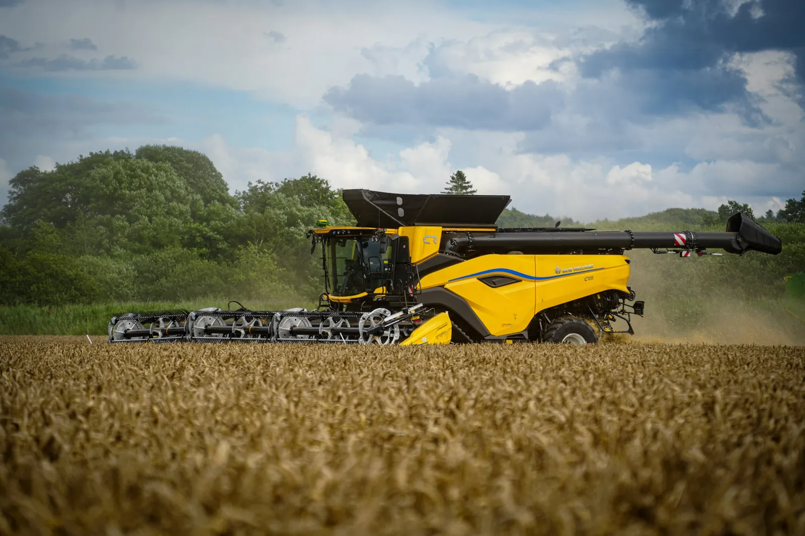 New Holland CR combine harvesting wheat with a StarFire receiver on the cab roof