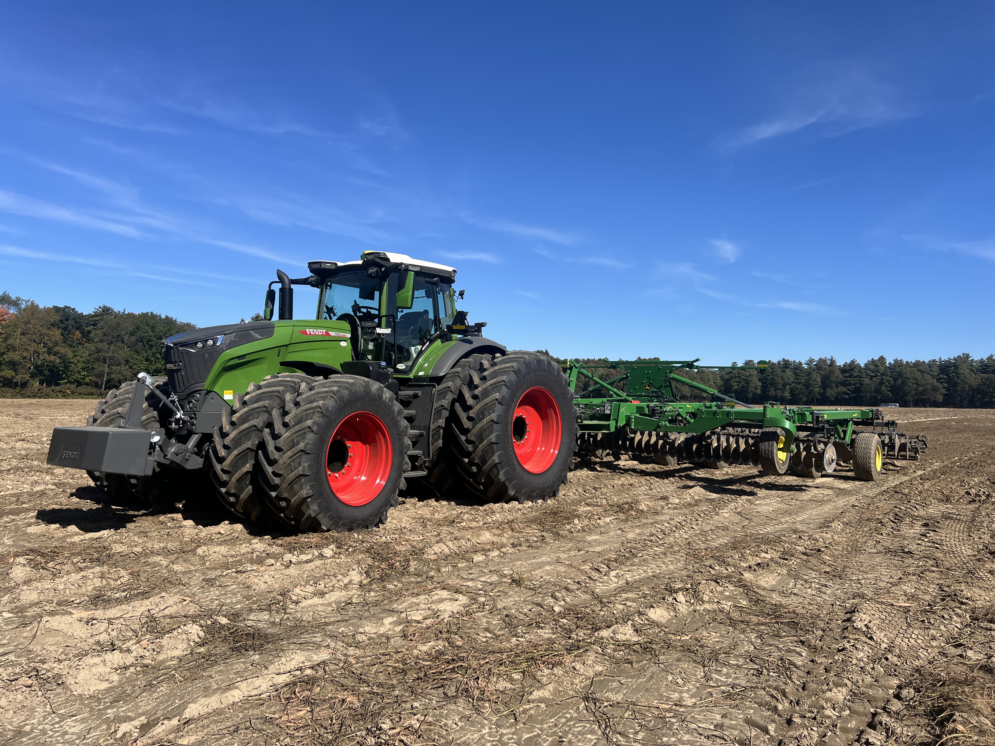 Fendt tractor with dual wheels and a John Deere® cultivation implement during field testing